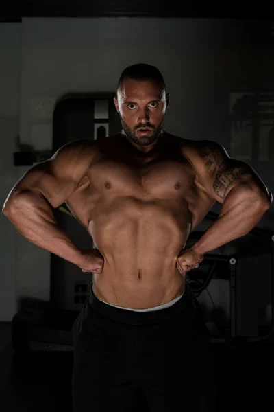 Idrottsman muskulös Bodybuilder poserar i gymmet — Stockfoto