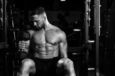 Pazı egzersiz Dumbbells ile genç adam