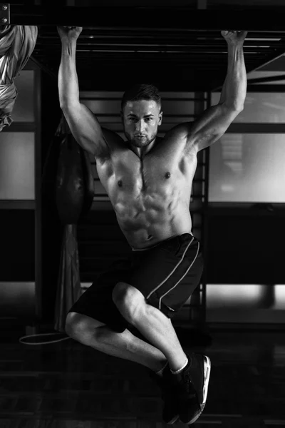 Joven hombre realizando colgante pierna levanta el ejercicio Abs —  Fotos de Stock