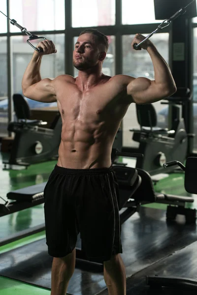 Unga Bodybuilder gör övning för Biceps på maskin — Stockfoto