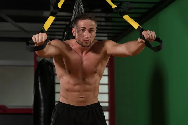 Junger attraktiver Mann trainiert mit trx Fitnessbändern — Stockfoto