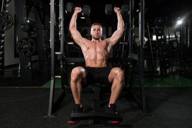 Bir spor salonunda egzersiz Dumbbells ile omuz