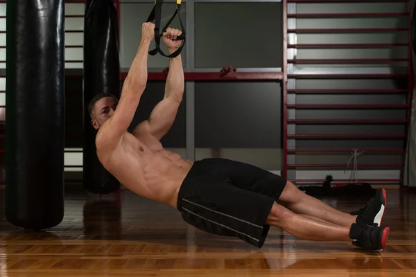 Entrenamiento de hombre atractivo joven con correas de fitness Trx —  Fotos de Stock