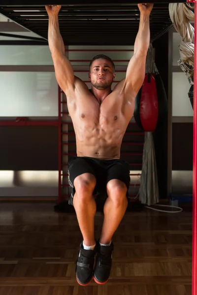 Joven hombre realizando colgante pierna levanta el ejercicio Abs —  Fotos de Stock