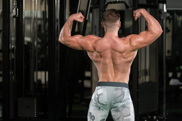 Muscular Homem Flexante Músculos Traseiros Duplo Biceps Pose — Fotografia de Stock