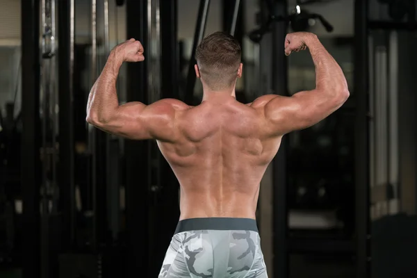 Muscular Man Flexing Muscles Rear Double Biceps Pose — Stock Photo, Image