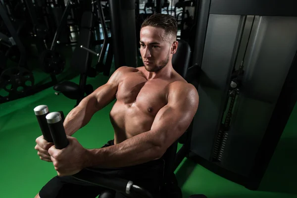 Hombre en el gimnasio ejercitando el pecho en la máquina —  Fotos de Stock