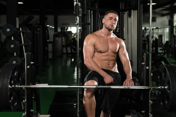 Gespierde man buigen spieren in de sportschool — Stockfoto