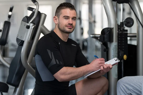 Personal Trainer Takes Notes While Man Exercising Chest — Stock Photo, Image