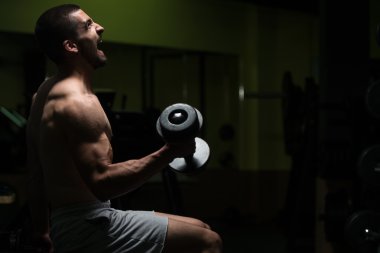 Pazı egzersiz Dumbbells ile genç adam