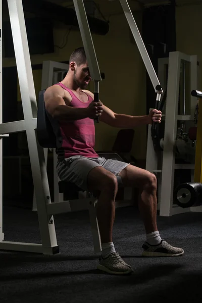 Hombre en el gimnasio ejercitando el pecho en la máquina —  Fotos de Stock