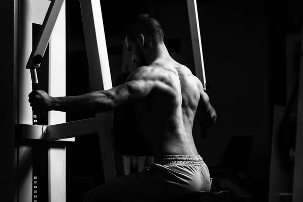 Hombre joven haciendo ejercicio de nuevo en el gimnasio —  Fotos de Stock