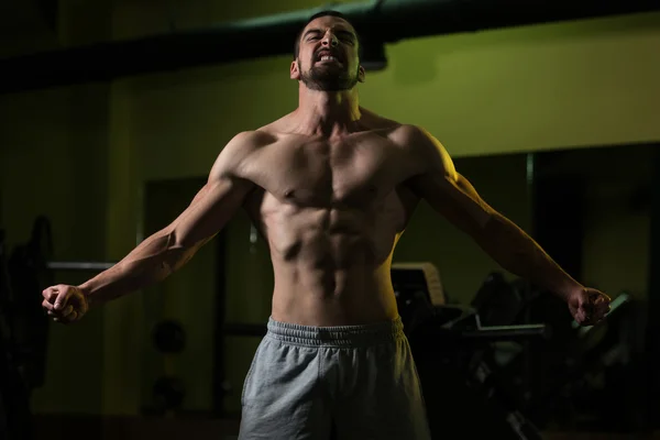 Kaslı adam içinde jimnastik salonu kas esneme — Stok fotoğraf