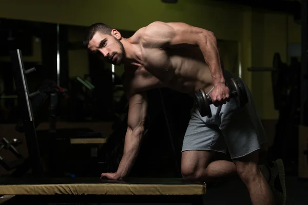 Exercício de tríceps com halteres no quarto escuro — Fotografia de Stock