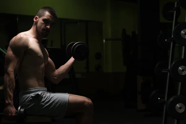 Biceps ćwiczenia z hantle w ciemnym pokoju — Zdjęcie stockowe