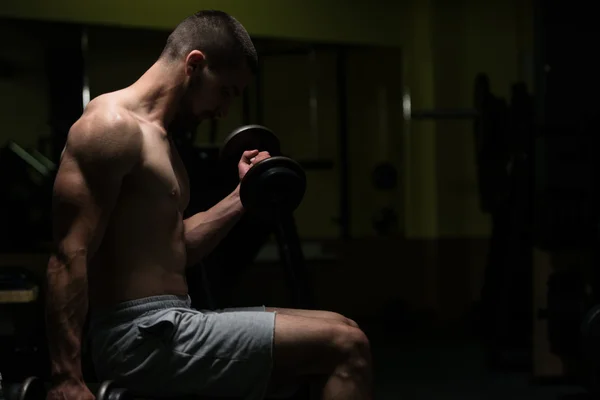 Biceps ćwiczenia z hantle w ciemnym pokoju — Zdjęcie stockowe