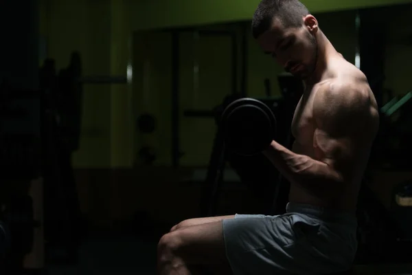 Hombre en el gimnasio ejercitando bíceps con sombrillas —  Fotos de Stock