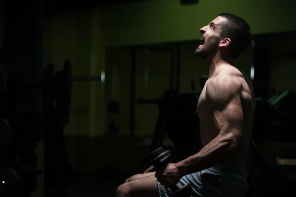 Biceps ćwiczenia z hantle w ciemnym pokoju — Zdjęcie stockowe