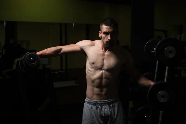 Mann im Fitnessstudio trainiert Schulter mit Hantel — Stockfoto