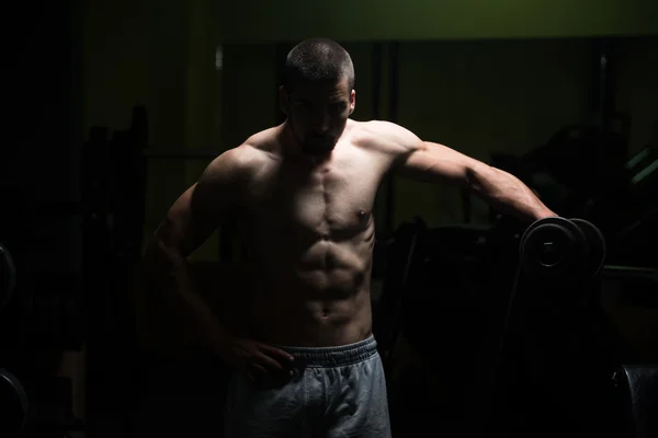 Exercice d'épaule avec haltère dans la chambre noire — Photo