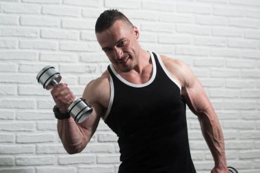 Egzersiz pazı Dumbbells ile genç adam
