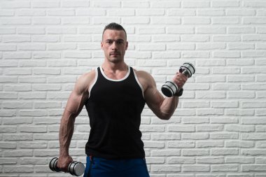 Pazı egzersiz beyaz tuğla zemin üzerine Dumbbells ile