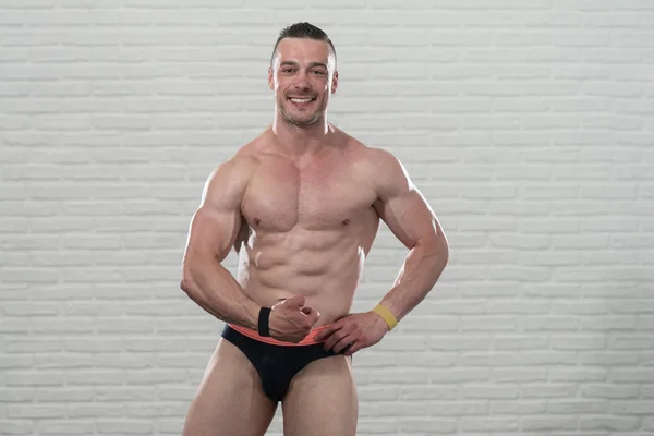 Muskulös manliga kroppen isolerad på vita klossar bakgrund — Stockfoto