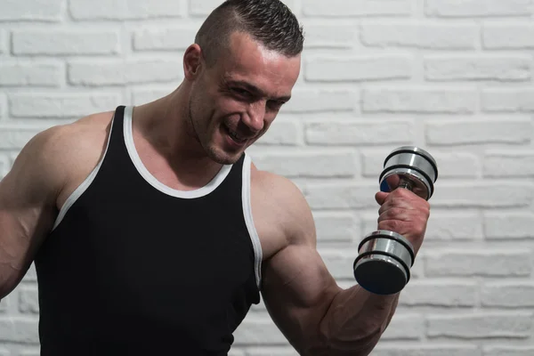 Człowieka, ćwiczenia na Biceps na tle białej cegły — Zdjęcie stockowe