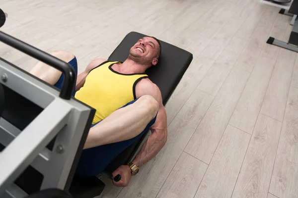 Hombre en el gimnasio en el ejercicio de la máquina — Foto de Stock