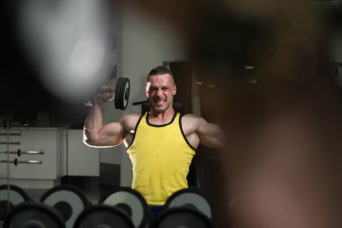 Omuz egzersiz Dumbbells ile genç adam
