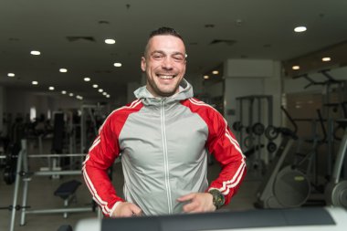 Genç adam bir koşu bandı üzerinde egzersiz