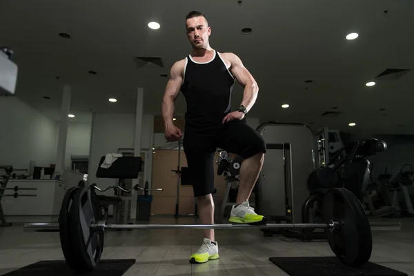 Homem muscular exercitando de volta com Barbell no ginásio — Fotografia de Stock