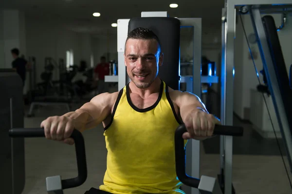 Ejercicios del pecho del entrenamiento del hombre en una máquina — Foto de Stock