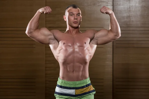 Kulturista Fitness Model představuje dvojitý Biceps po cvičení — Stock fotografie