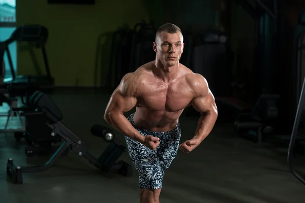 Junger Bodybuilder lässt Muskeln spielen — Stockfoto