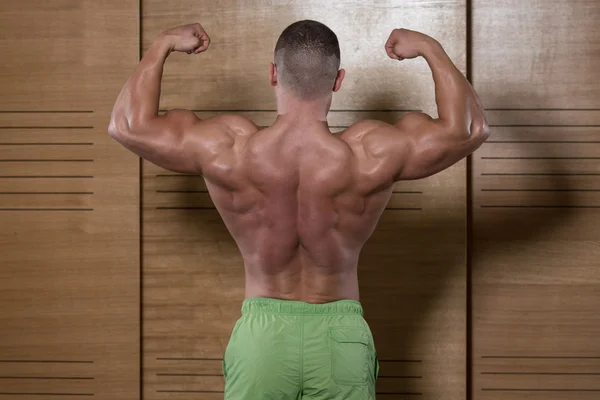 肌肉男弯曲背部肌肉的姿势 — 图库照片