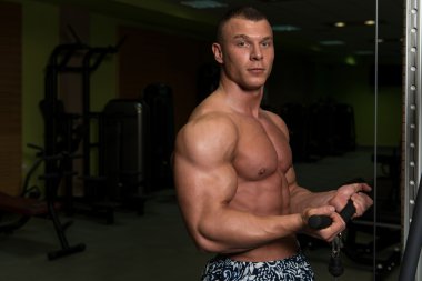 Kaslı adam pazı kablo makinede egzersiz