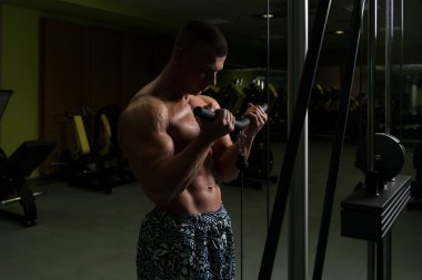 Pazı kablo makine için egzersiz yapan erkek