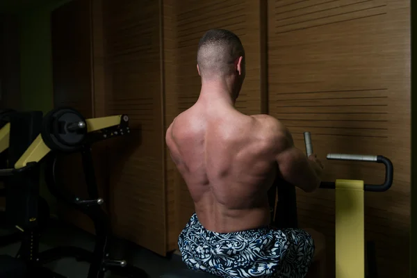Bodybuilder oefening terug op Machine — Stockfoto
