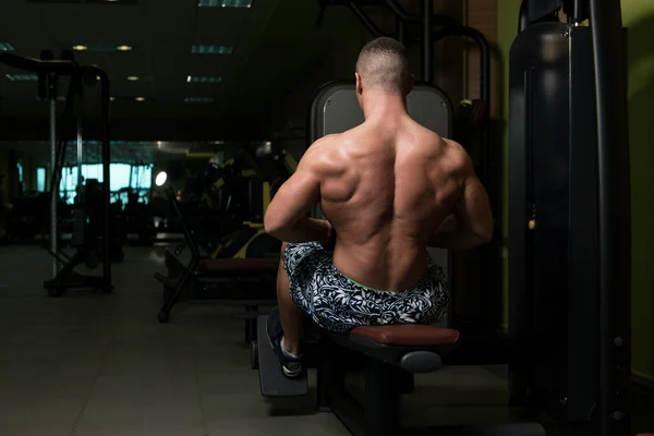 Fitness muskel Man motion tillbaka på maskin — Stockfoto