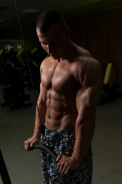 Joven ejercitando tríceps en el gimnasio — Foto de Stock