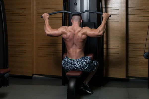 Fitness cvičení svalů člověka zpět na stroj — Stock fotografie