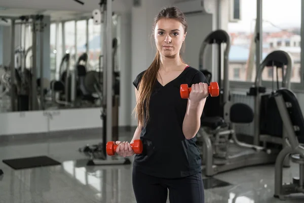 Mladá žena cvičit Biceps s činkami — Stock fotografie