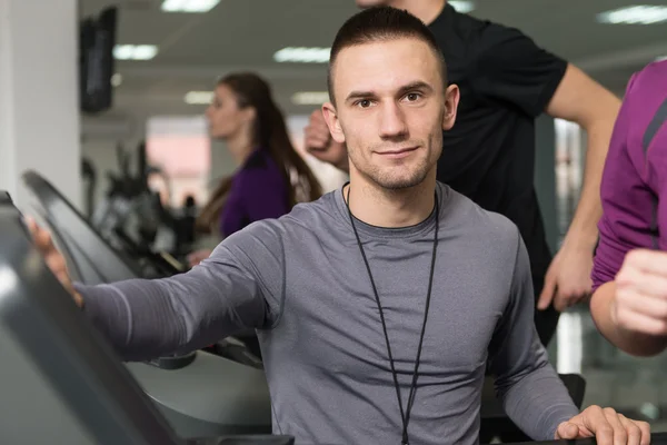 Groupe de personnes courant sur des tapis roulants dans la salle de gym — Photo