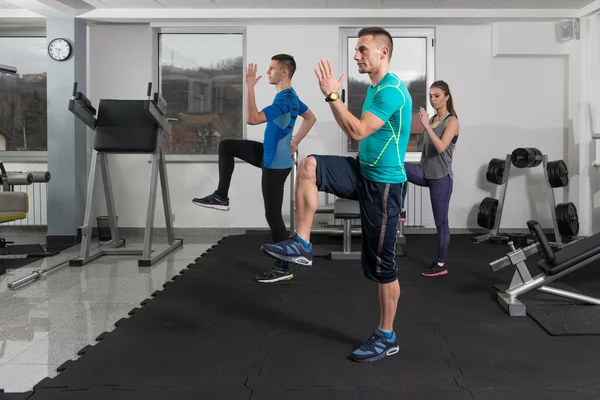 Le persone che si allungano durante la classe di fitness nel centro fitness — Foto Stock