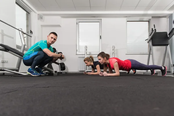 Personas que se estiran durante la clase de fitness en el gimnasio — Foto de Stock