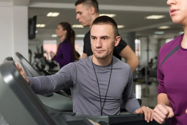 Entraîneur personnel et client en salle de gym sur tapis roulants — Photo