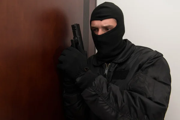 Грабитель вламывается в дом с пистолетом — стоковое фото