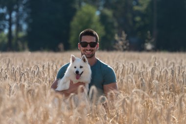 Adam ve hasat alanında oturan köpek
