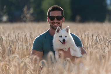 Adam ve hasat alanında oturan köpek